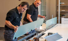 Two office workers are fixing the table and arranging the office workspace.