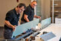 Two office workers are fixing the table and arranging the office workspace.