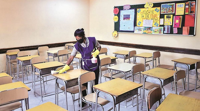 A Woman Sanitizing The Classroom Furnitures - Classroom Precautions During Covid-19.
