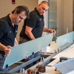 Two office workers are fixing the table and arranging the office workspace.